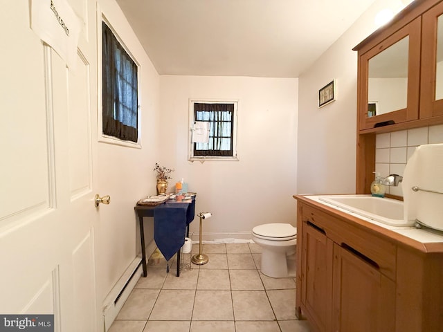 bathroom with tasteful backsplash, tile patterned flooring, vanity, a baseboard heating unit, and toilet