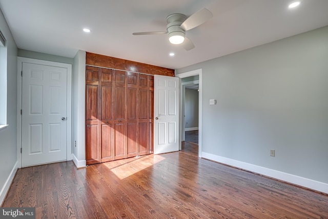 unfurnished bedroom with hardwood / wood-style floors, a closet, and ceiling fan