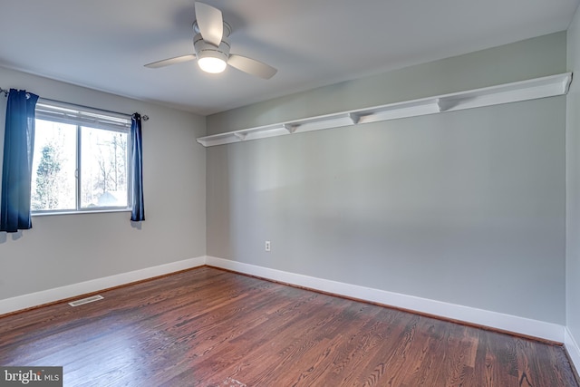 spare room with dark wood-type flooring and ceiling fan