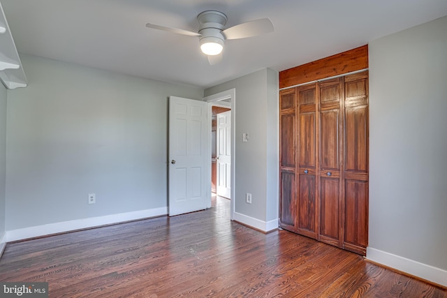 unfurnished bedroom with ceiling fan, dark hardwood / wood-style flooring, and a closet