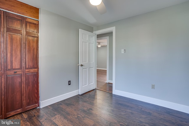 unfurnished bedroom featuring dark wood-type flooring and ceiling fan