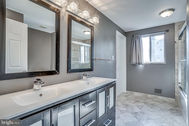 bathroom with vanity and bath / shower combo with glass door