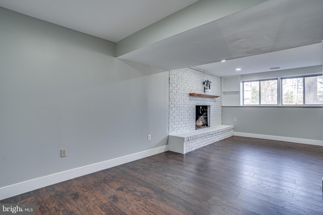 unfurnished living room with dark wood-type flooring and a fireplace