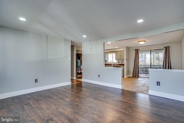 unfurnished living room featuring sink and light hardwood / wood-style floors