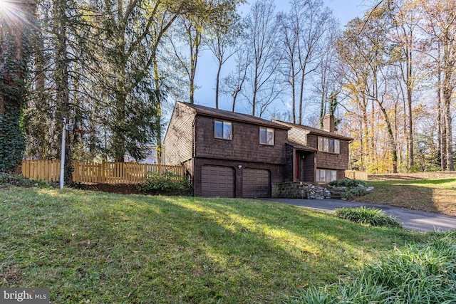 raised ranch with a garage and a front lawn