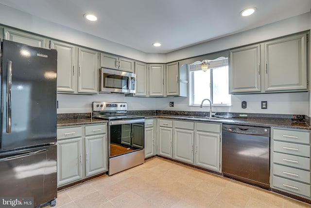 kitchen with dark stone counters, gray cabinets, sink, and black appliances