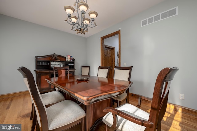 dining area with an inviting chandelier and light wood-type flooring