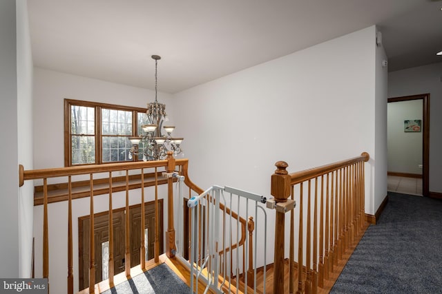 stairs featuring a chandelier and carpet flooring