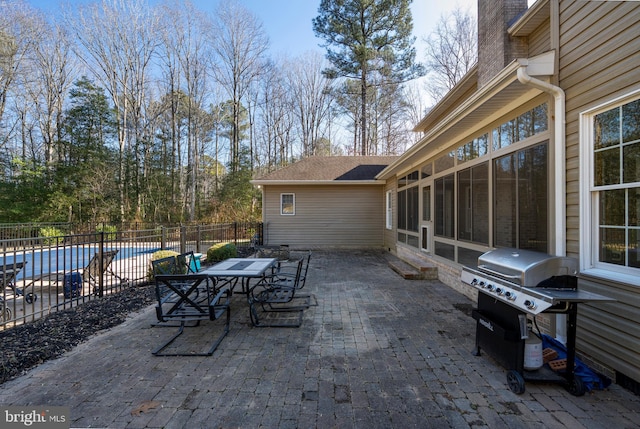 view of patio featuring area for grilling, a sunroom, and a covered pool