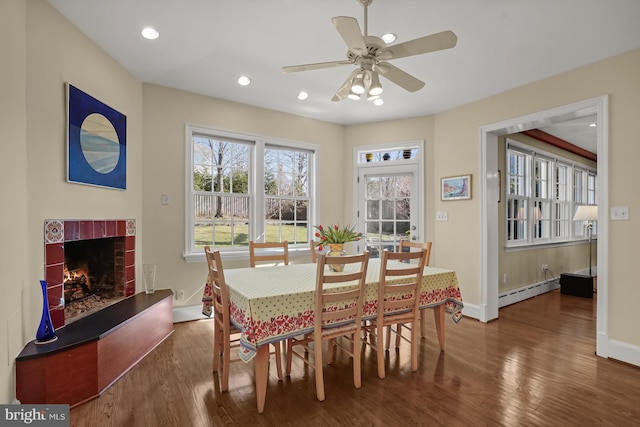 dining space with a baseboard heating unit, dark hardwood / wood-style floors, and ceiling fan