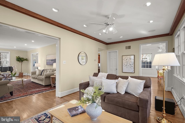 living room featuring light hardwood / wood-style flooring, ornamental molding, and ceiling fan