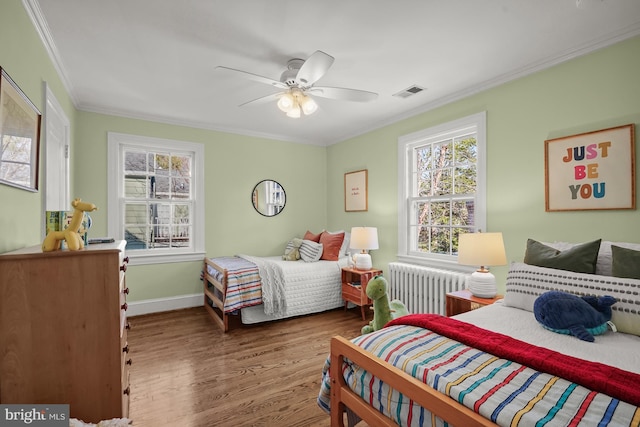 bedroom featuring radiator, ornamental molding, hardwood / wood-style floors, and ceiling fan