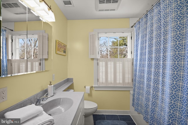 bathroom featuring plenty of natural light, toilet, tile patterned flooring, and vanity