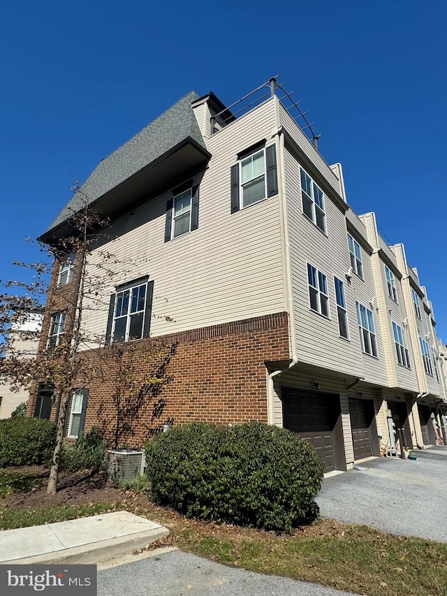 view of property exterior featuring central AC and a garage