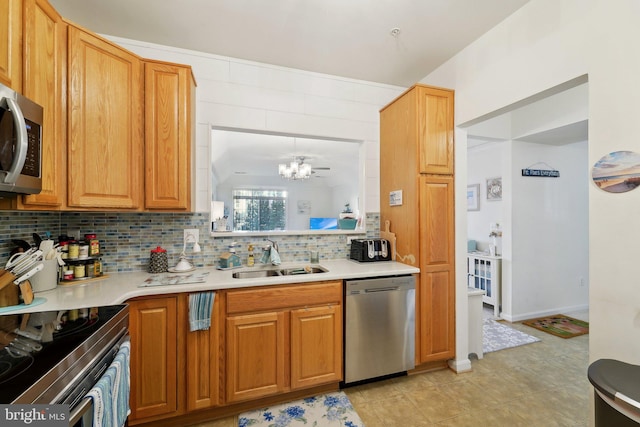 kitchen with sink, decorative backsplash, a notable chandelier, and appliances with stainless steel finishes