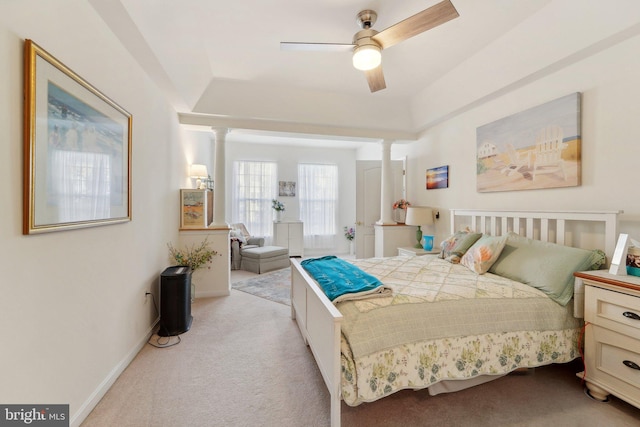 carpeted bedroom featuring a raised ceiling and ceiling fan