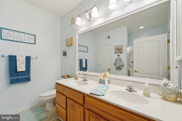 bathroom featuring tile patterned flooring, vanity, a shower with shower door, and toilet