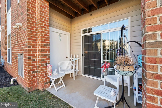 view of exterior entry with a patio