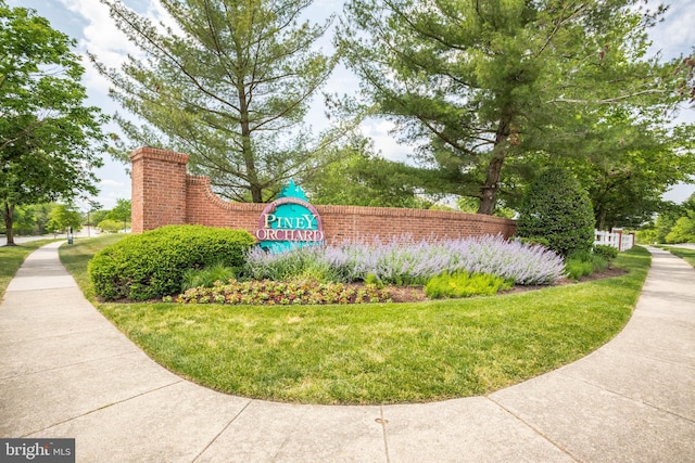 community / neighborhood sign featuring a yard