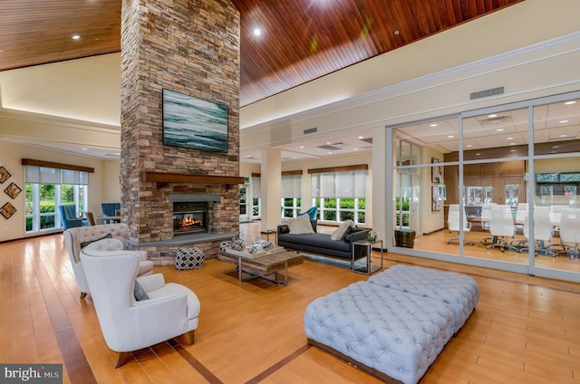 living room with a high ceiling, wood-type flooring, wood ceiling, and a fireplace