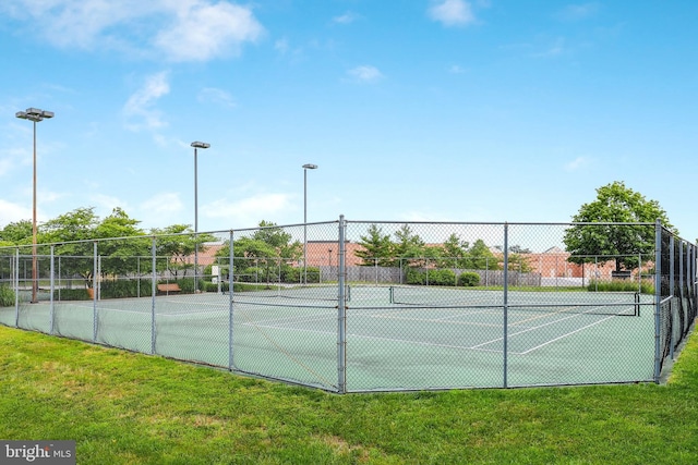 view of tennis court featuring a lawn