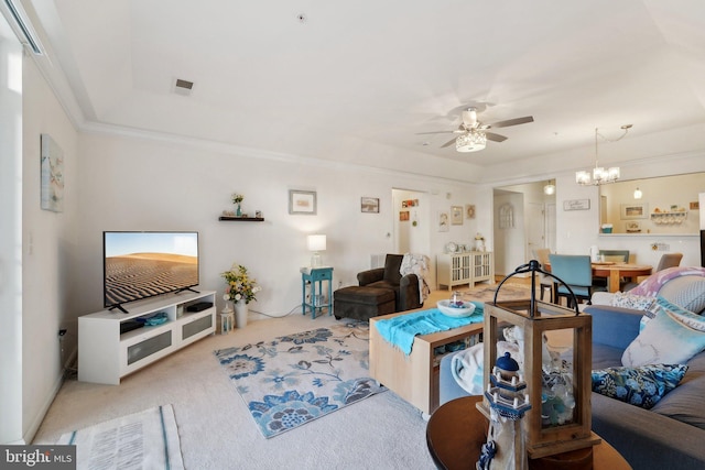 living room featuring crown molding, ceiling fan with notable chandelier, and light carpet