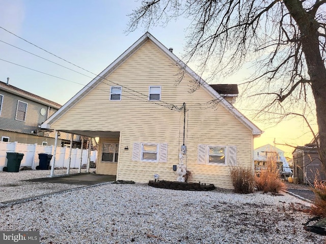 back house at dusk with a carport