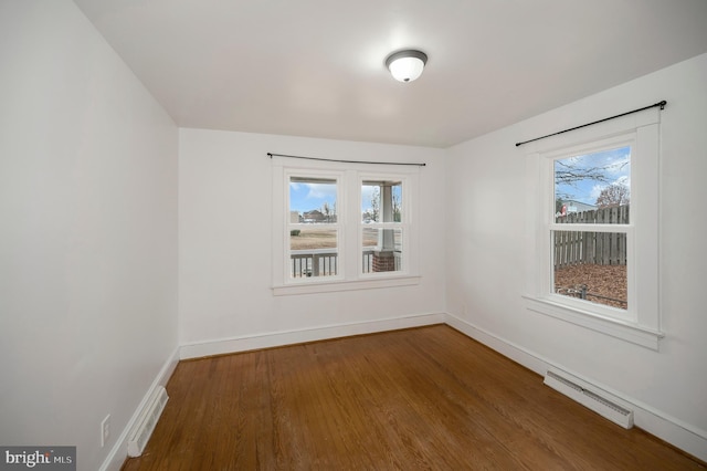 spare room with plenty of natural light and hardwood / wood-style floors