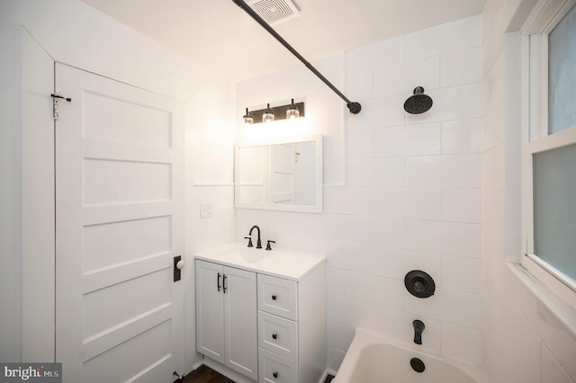 bathroom with tiled shower / bath and vanity