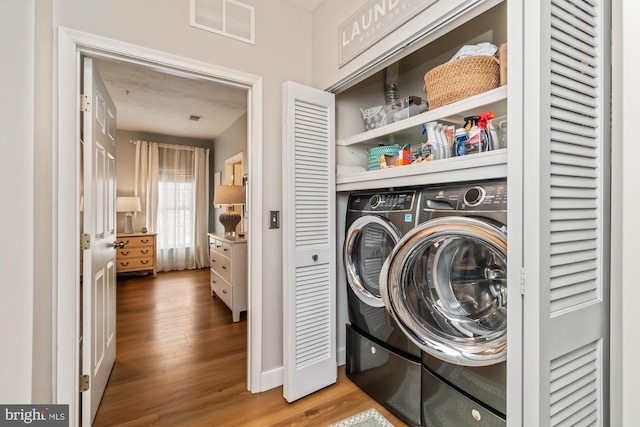 laundry room with hardwood / wood-style flooring and independent washer and dryer