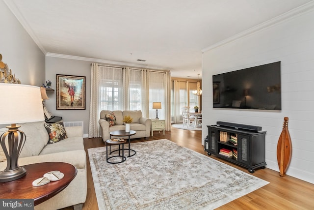 living room featuring crown molding, a chandelier, and hardwood / wood-style floors