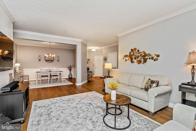 living room featuring ornamental molding, dark hardwood / wood-style flooring, and a notable chandelier