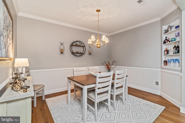 dining room featuring crown molding, a notable chandelier, and light hardwood / wood-style floors