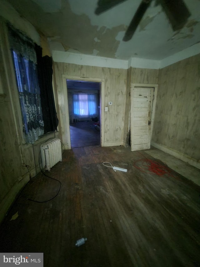 miscellaneous room with dark wood-type flooring and radiator heating unit