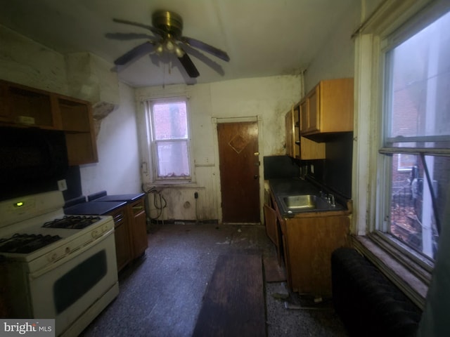 kitchen with sink, white gas range oven, and ceiling fan