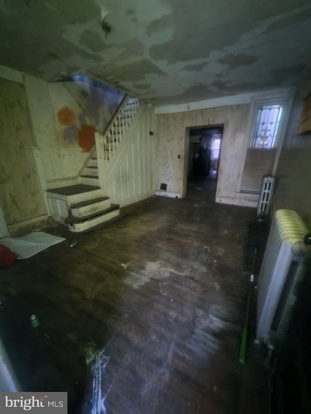 basement with radiator heating unit and dark wood-type flooring