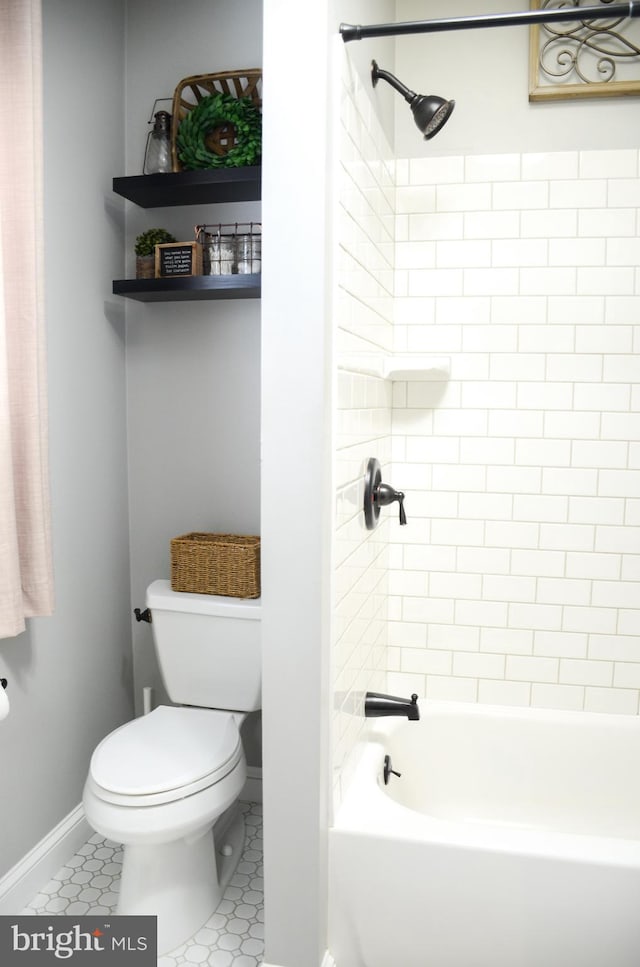 bathroom with toilet and tiled shower / bath combo