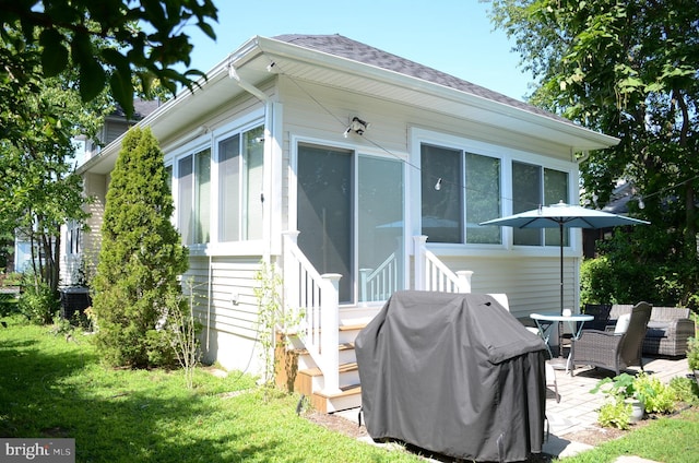 rear view of house with a patio and a yard