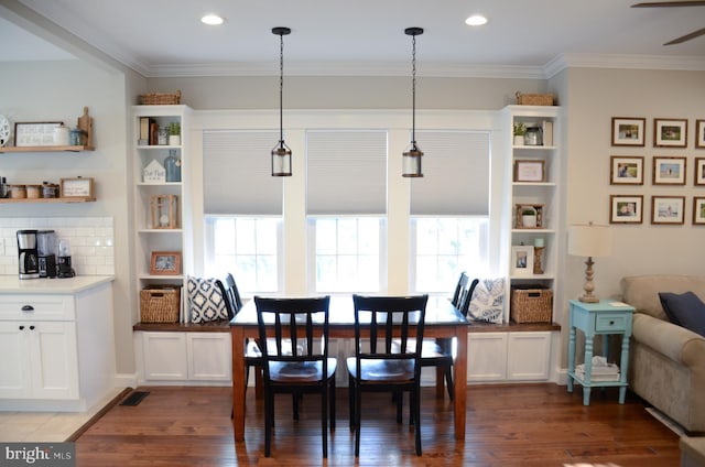 dining room featuring crown molding, dark wood-type flooring, and ceiling fan