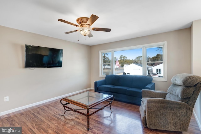 living room featuring ceiling fan and dark hardwood / wood-style flooring