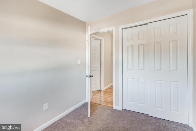 unfurnished bedroom with a closet and carpet flooring