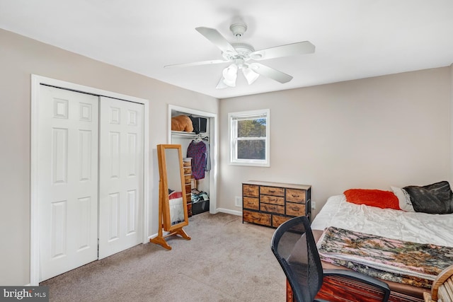 bedroom with multiple closets, ceiling fan, and light carpet