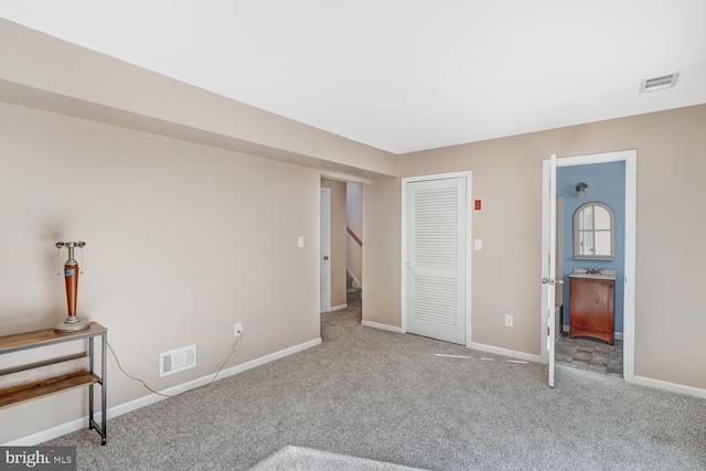 unfurnished bedroom with a closet and light carpet