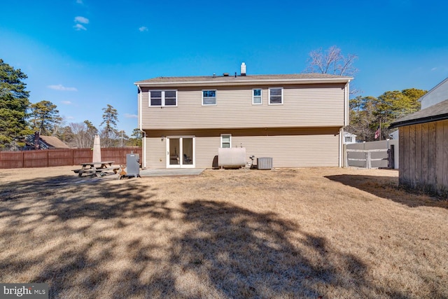 rear view of property featuring cooling unit, a yard, and a patio area