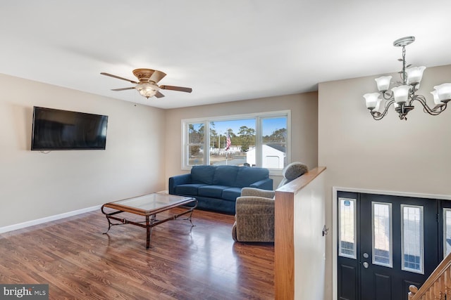 living room with ceiling fan with notable chandelier and dark wood-type flooring