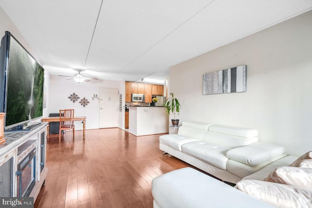 living room with light hardwood / wood-style flooring and ceiling fan