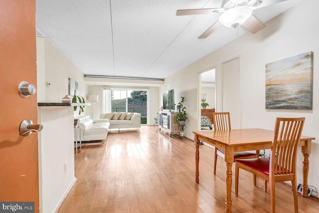 dining space with ceiling fan, wood-type flooring, and a textured ceiling