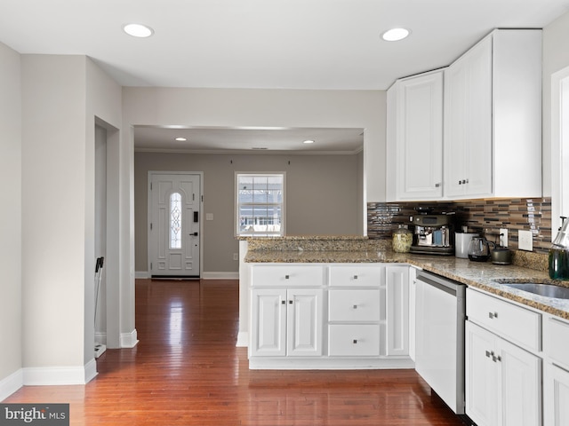 kitchen with white cabinetry, dishwasher, kitchen peninsula, light stone countertops, and backsplash