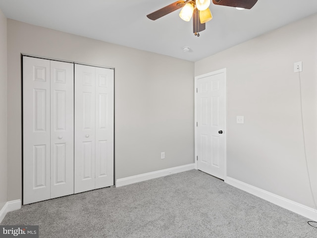 unfurnished bedroom with light colored carpet, a closet, and ceiling fan