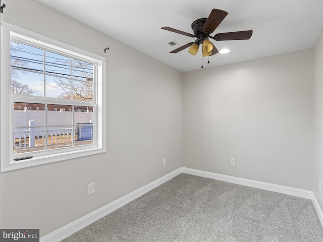 carpeted spare room with ceiling fan